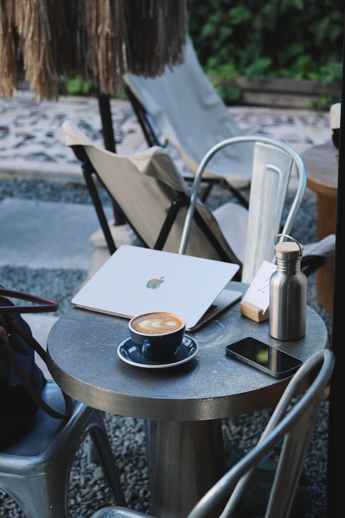 Outdoor workspace setup with laptop and coffee, offering a relaxing work environment.